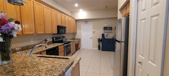 kitchen with light tile floors, decorative light fixtures, light stone countertops, black appliances, and sink