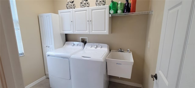 laundry area with hookup for a washing machine, cabinets, sink, and washing machine and dryer