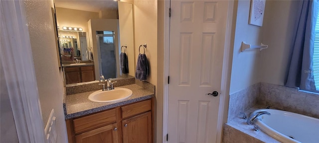 bathroom featuring oversized vanity and a relaxing tiled bath