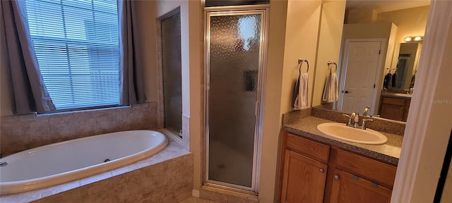 bathroom featuring plenty of natural light, shower with separate bathtub, tile floors, and vanity with extensive cabinet space