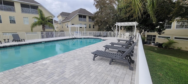 view of pool featuring a lawn, a pergola, and a patio