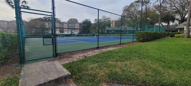 view of sport court with a lawn