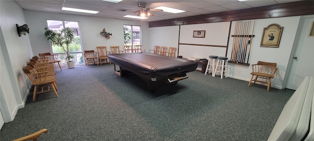 rec room featuring dark colored carpet, pool table, ceiling fan, and a drop ceiling