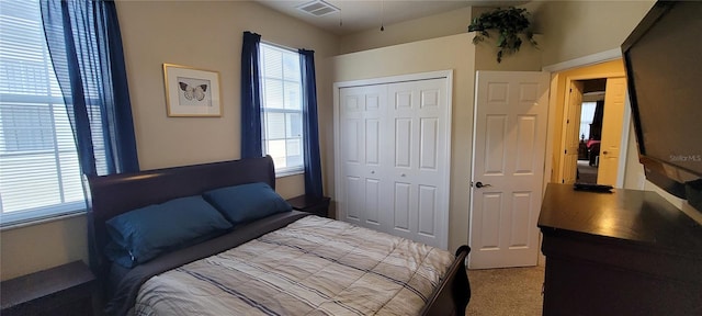 bedroom featuring light carpet, a closet, and multiple windows