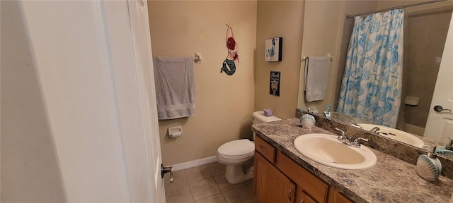 bathroom with toilet, large vanity, and tile flooring