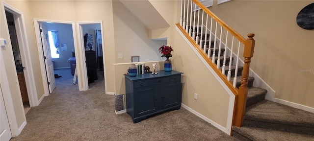 stairway featuring dark colored carpet