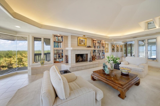 tiled living room featuring a raised ceiling and a tile fireplace