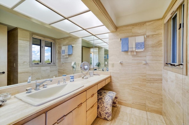 bathroom featuring tile walls, vanity with extensive cabinet space, and tile flooring