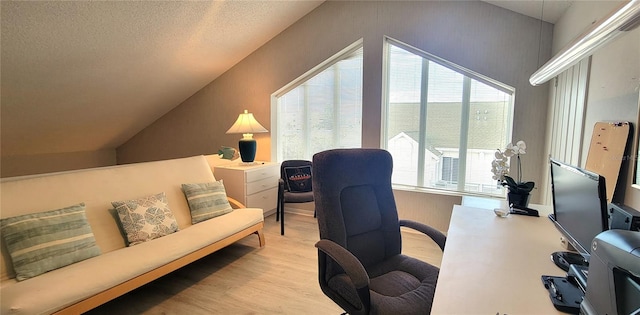 office area featuring light wood-type flooring, a textured ceiling, and vaulted ceiling