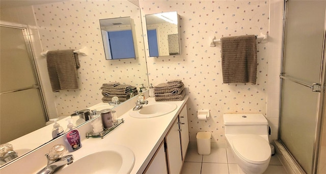 bathroom featuring toilet, vanity, tile patterned floors, and a shower with shower door