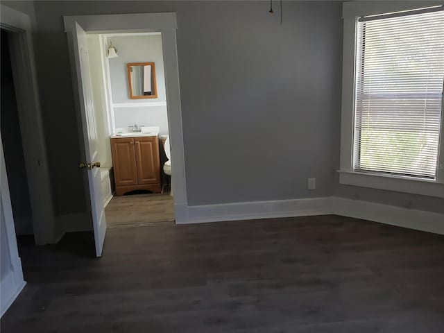 unfurnished bedroom with dark hardwood / wood-style floors and sink