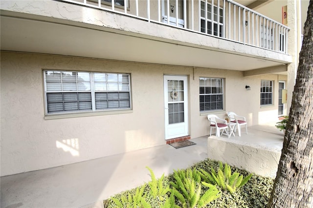 property entrance featuring a balcony and a patio