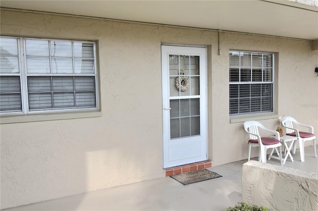 view of exterior entry with a patio