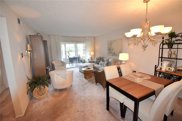 dining space with light carpet, a notable chandelier, and a textured ceiling