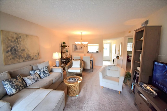 carpeted living room with a textured ceiling and a chandelier