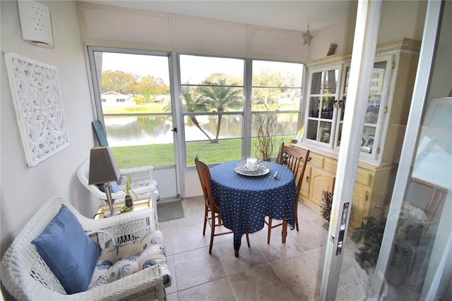 sunroom featuring a water view