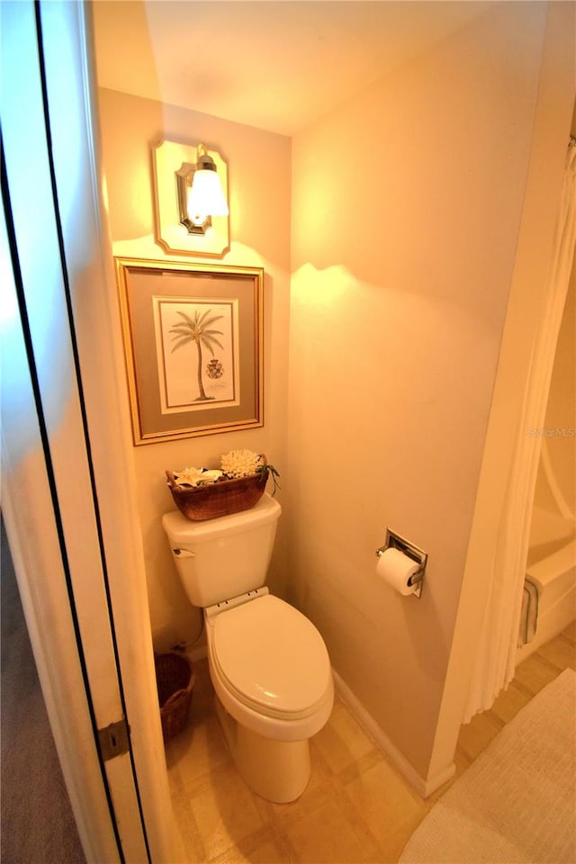 bathroom featuring tile flooring and toilet