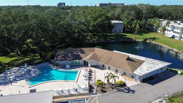 view of swimming pool with a patio area, a lawn, and a water view