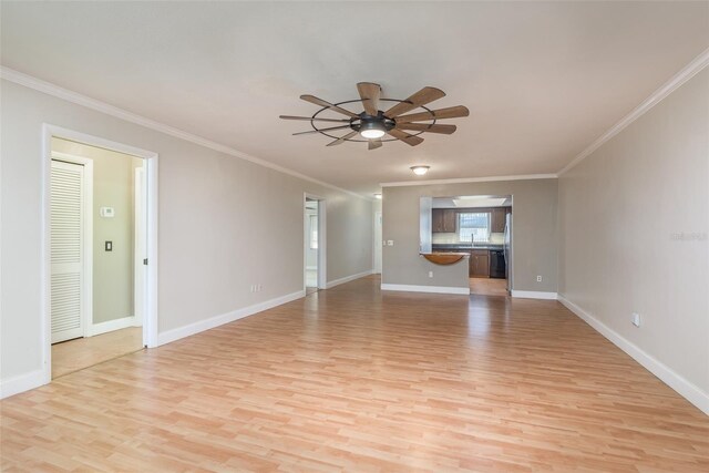 unfurnished living room with ceiling fan, sink, crown molding, and light hardwood / wood-style flooring