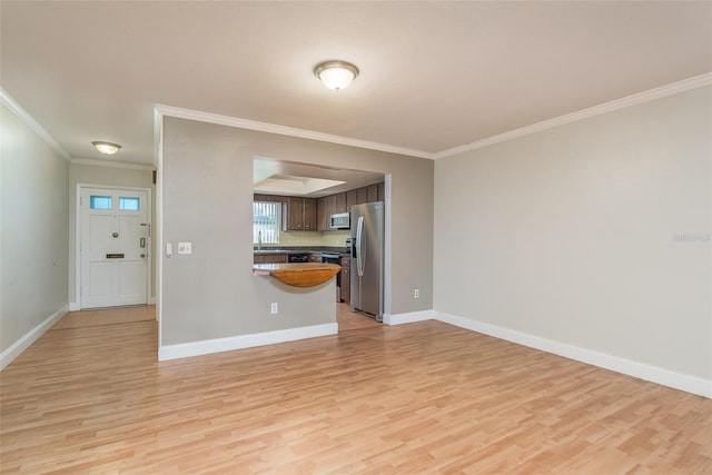 unfurnished living room featuring light hardwood / wood-style floors, sink, and crown molding