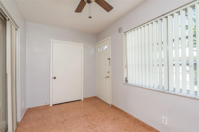 tiled entryway with plenty of natural light and ceiling fan