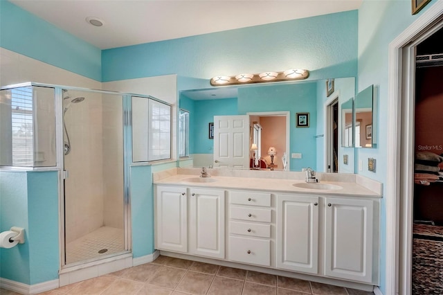 bathroom featuring tile patterned flooring, a shower with door, and vanity