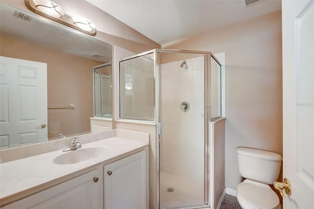 bathroom featuring a textured ceiling, tile patterned flooring, vanity, toilet, and a shower with door