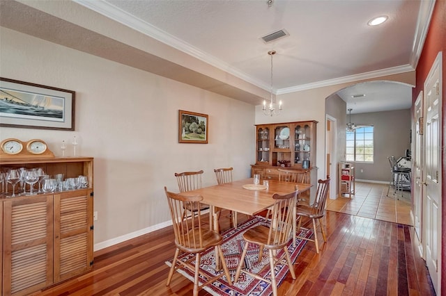 dining room with ceiling fan with notable chandelier, wood-type flooring, ornamental molding, and a textured ceiling