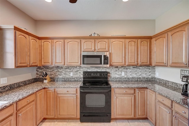 kitchen with light tile patterned floors, black / electric stove, dark stone counters, and tasteful backsplash