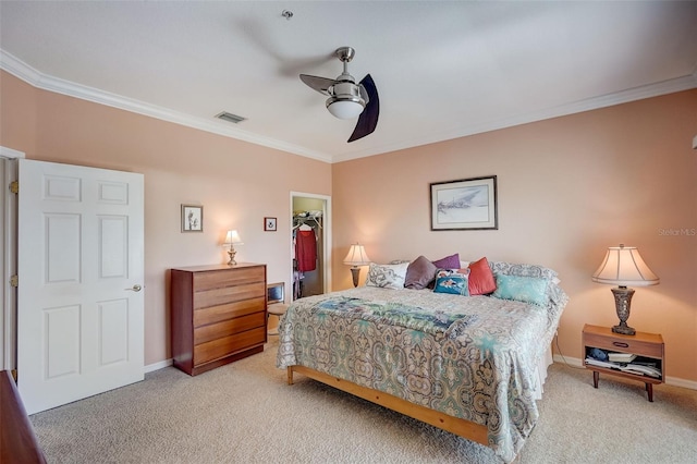 bedroom featuring ceiling fan, light colored carpet, a walk in closet, a closet, and crown molding