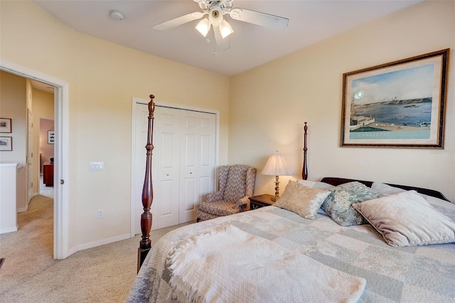 bedroom with a closet, light colored carpet, ceiling fan, and baseboards