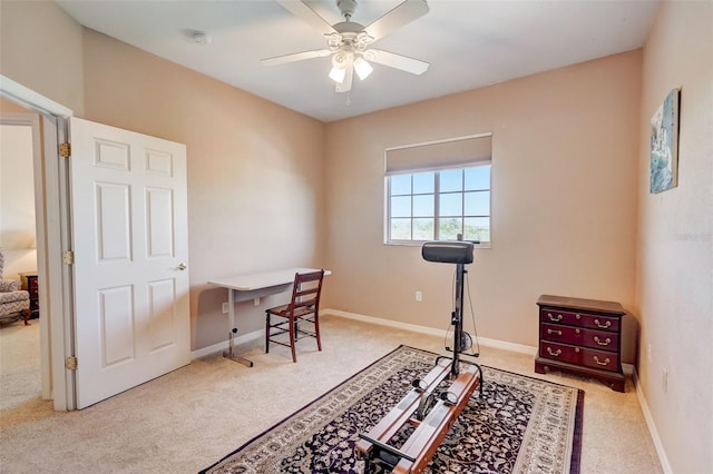 carpeted office space featuring ceiling fan