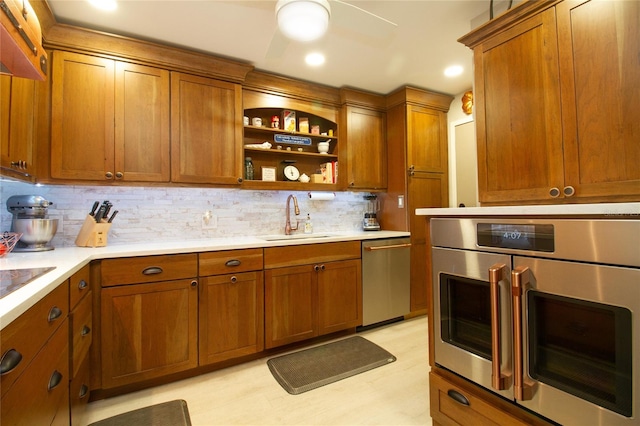 kitchen with tasteful backsplash, light wood-type flooring, appliances with stainless steel finishes, and sink