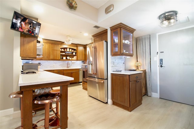 kitchen with backsplash, ceiling fan, light hardwood / wood-style floors, and high quality fridge