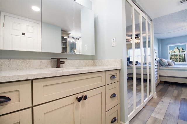 bathroom with hardwood / wood-style floors, a textured ceiling, and vanity