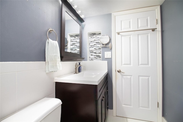 bathroom featuring toilet, tile flooring, and vanity