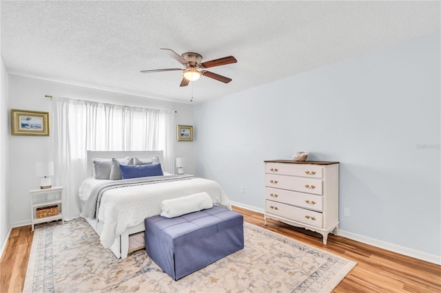 bedroom featuring a textured ceiling, light hardwood / wood-style flooring, and ceiling fan