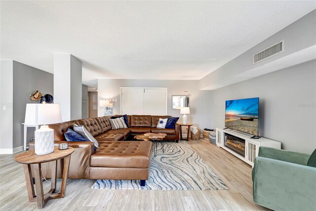 living room featuring a textured ceiling and light hardwood / wood-style flooring