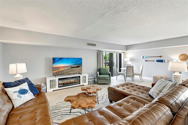 living room featuring a textured ceiling and light wood-type flooring