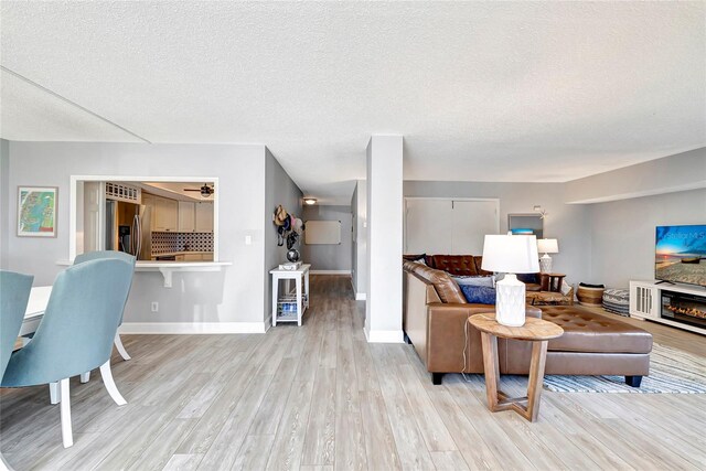 living room featuring a textured ceiling and light hardwood / wood-style floors