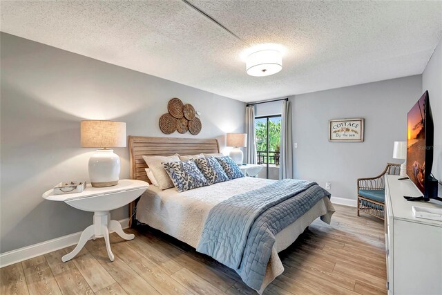 bedroom with light hardwood / wood-style flooring and a textured ceiling