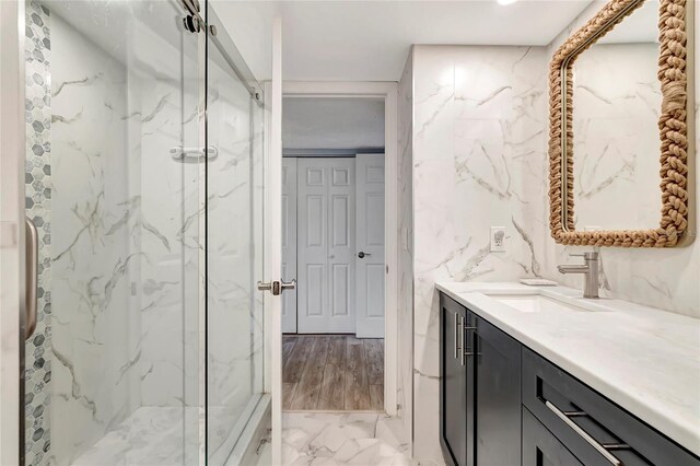 bathroom featuring tile walls, oversized vanity, an enclosed shower, and tile flooring