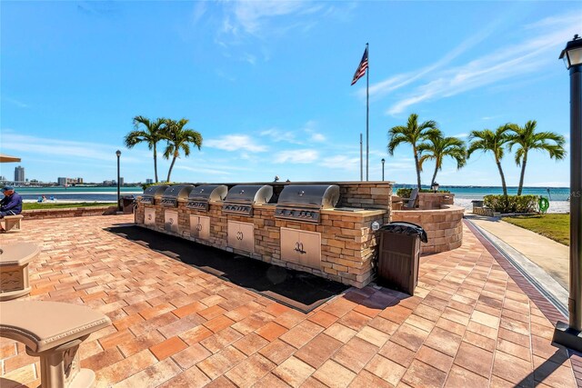 view of terrace featuring area for grilling, a grill, and a water view