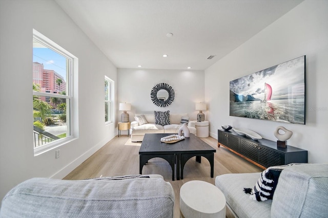 living room with plenty of natural light and light hardwood / wood-style flooring