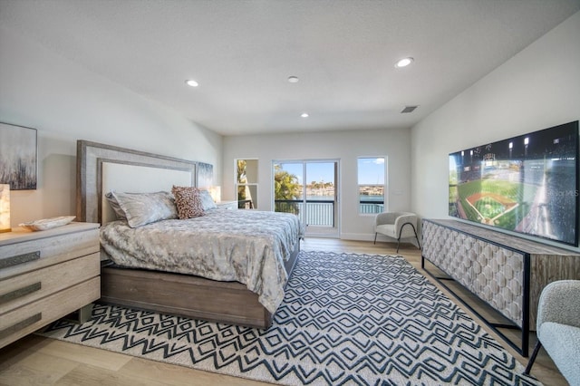 bedroom with access to exterior and light hardwood / wood-style floors