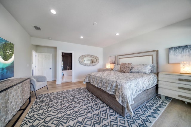 bedroom with dark hardwood / wood-style flooring and ensuite bathroom