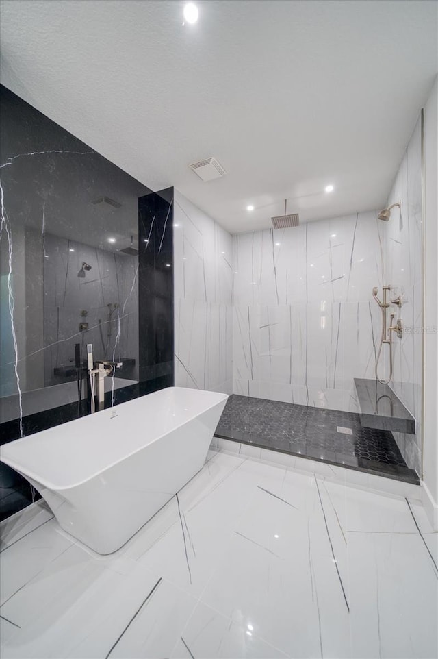 bathroom featuring tile walls, tiled shower, and tile flooring