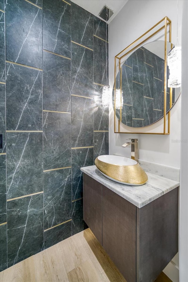 bathroom featuring tile walls, oversized vanity, and hardwood / wood-style flooring