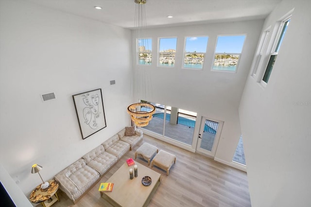 living room featuring a towering ceiling and light hardwood / wood-style flooring