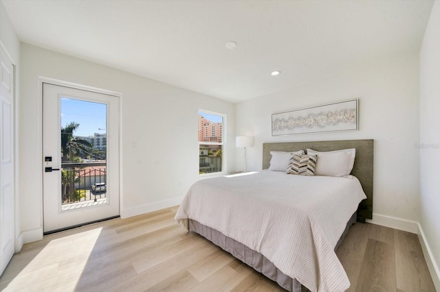 bedroom with access to exterior and light hardwood / wood-style flooring